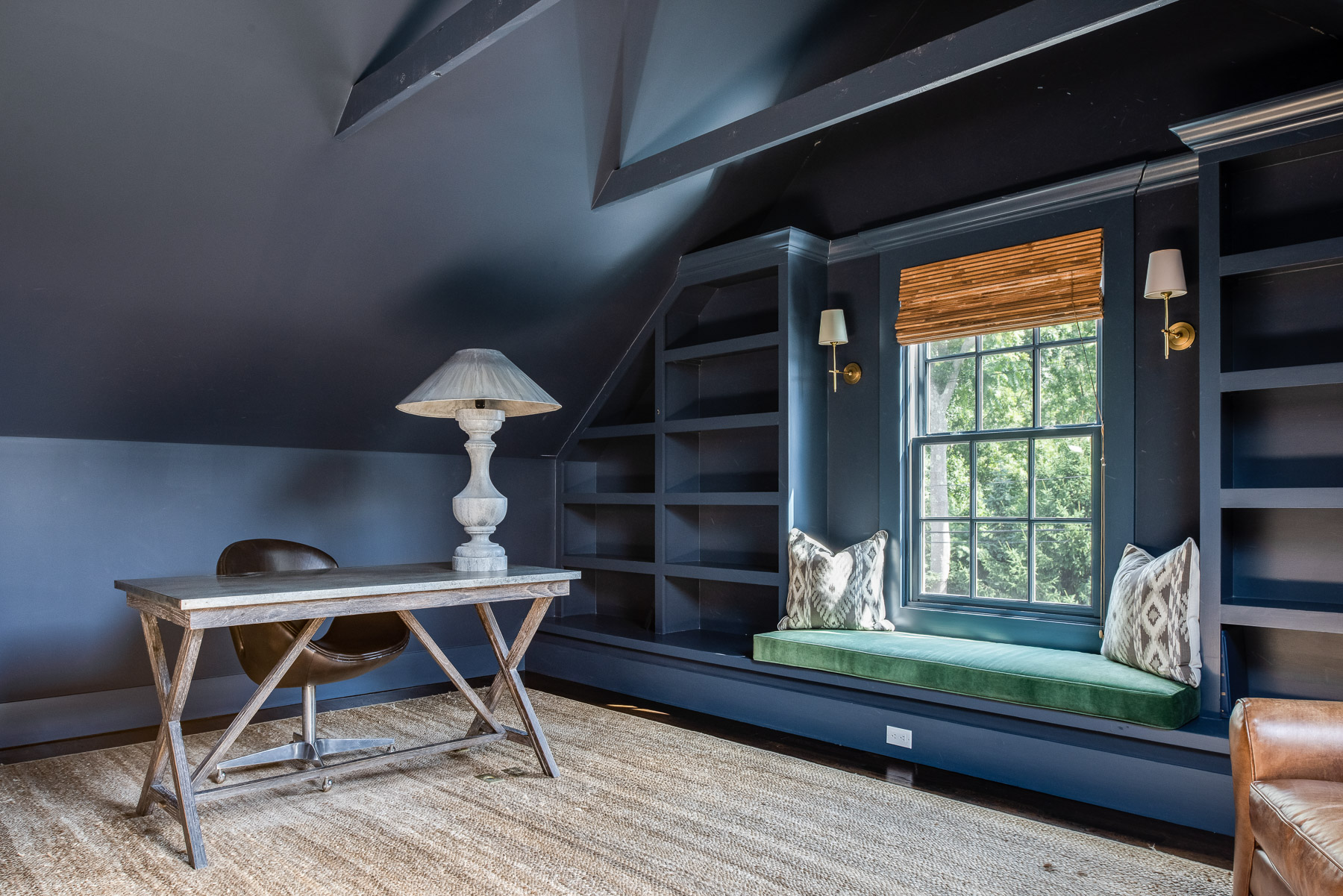 Navy reading nook with built-in shelving and window seat